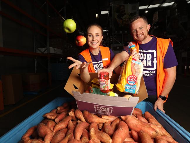 Foodbank volunteers Zoe Templeton and Anthony Deamon prepare hampers for the poor. Photo: Annette Dew