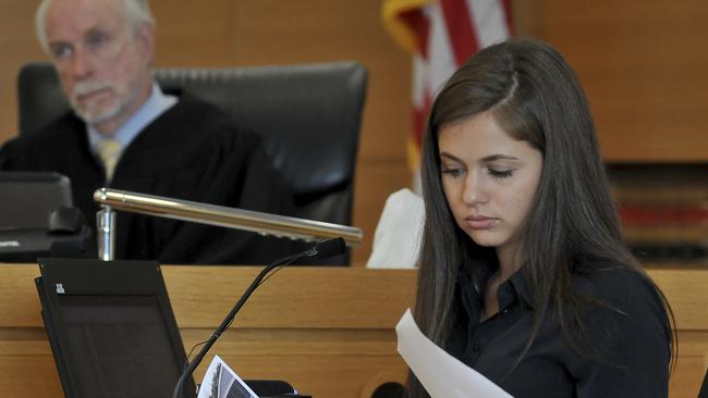 Samantha Boardman, 20, of Norfolk, Mass., a former friend of defendant Michelle Carter looks over photos that were taken at the Homers for Conrad fundraising event that Carter organised several months after Conrad Roy III died by suicide. Picture: Mark Stockwell/The Sun Chronicle via AP.