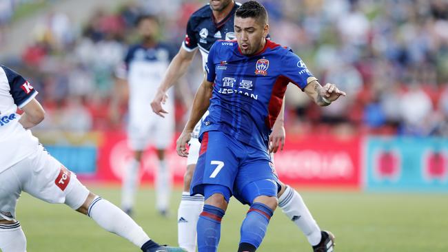 Newcastle Jets’ Dimitri Petratos takes on the Mebourne Victory defence.