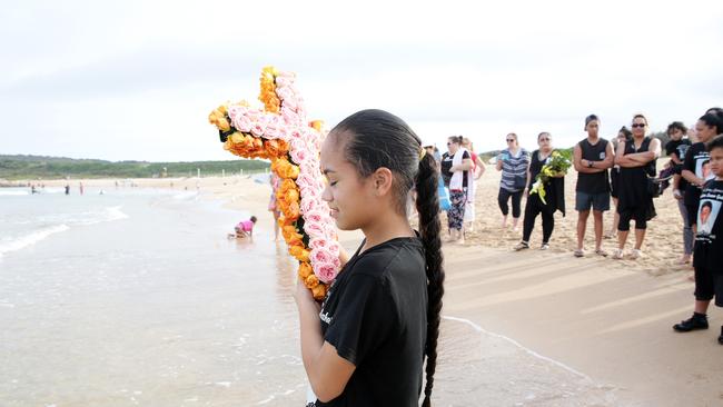 A young girl lays a floral tribute at South Maroubra beach in honour of 14 year old Tuipolotu Gallaher, who drowned there on December 27. Kingsford Smith MP Matt Thistlethwaite is leading the push for swimming lessons to be compulsory in schools. Picture: Carly Earl/