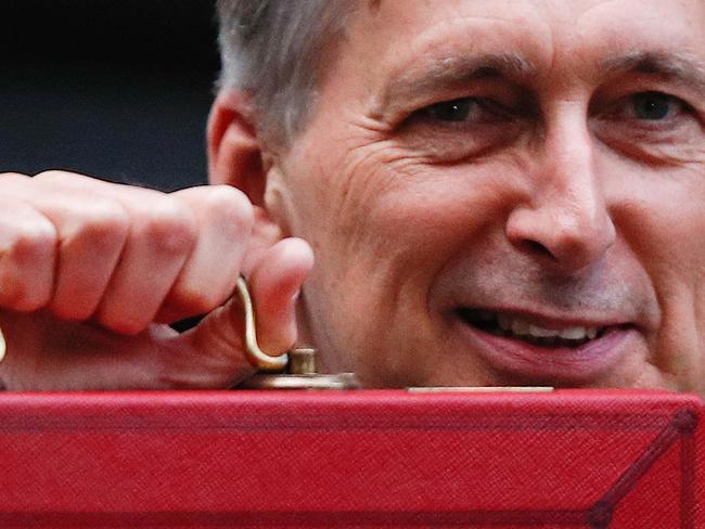 British Chancellor of the Exchequer Philip Hammond poses for pictures with the Budget Box as he leaves 11 Downing Street in London, on October 29, 2018, before presenting the government's annual Autumn budget to Parliament. - Chancellor of the Exchequer, Hammond will try to navigate a political minefield when he unveils a budget that could be scuppered by the final terms of Brexit next year. (Photo by Adrian DENNIS / AFP)