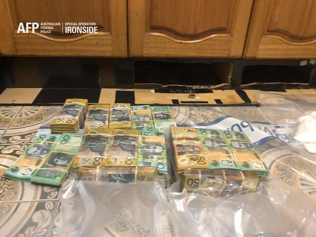 Cash found in raids was hidden behind kitchen cupboards .