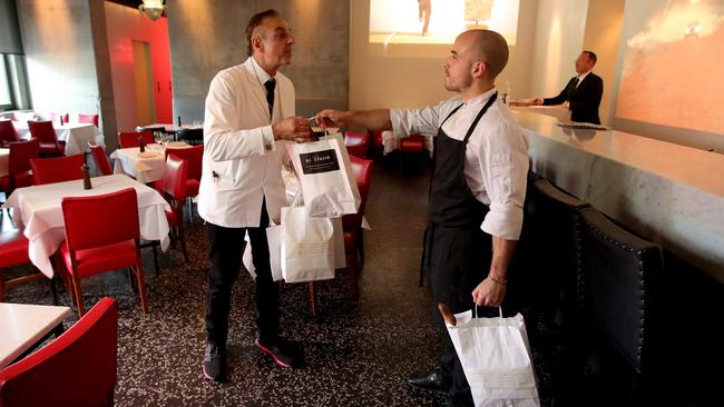 Di Stasio Citta chef Emanuele Cipollini, right, hands a takeaway order to waiter Marco Sellitto for delivery in Melbourne. Stuart McEvoy