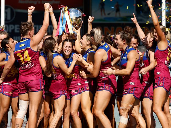 MELBOURNE, AUSTRALIA - DECEMBER 03: The Lions celebrate on the dais after winning during the 2023 AFLW Grand Final match between The North Melbourne Tasmanian Kangaroos and The Brisbane Lions at IKON Park on December 03, 2023 in Melbourne, Australia. (Photo by Michael Willson/AFL Photos via Getty Images)