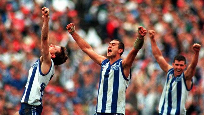 Dean Laidley, Wayne Schwass and Anthony Stevens celebrate North Melbourne’s 1996 premiership win.