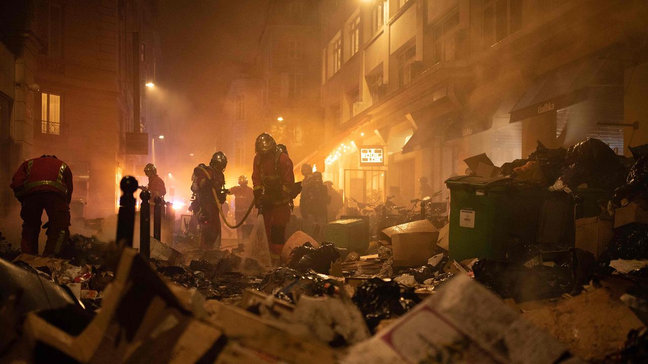 Firefighters checks rubbish after extinguishing a fire during a demonstration in Paris. Picture: AFP