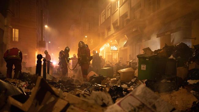 Firefighters checks rubbish after extinguishing a fire during a demonstration in Paris. Picture: AFP