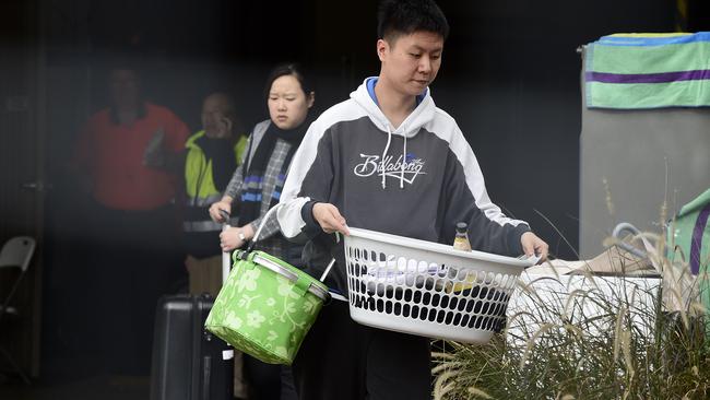 Residents are seen carrying their personal items out of Mascot Towers.