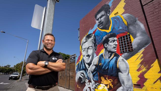 Ex AFL player Chris Johnson joins Fitzroy greats Kevin Murray and Jon Brown on the famous mural which was only completed on Friday. Picture: Jason Edwards