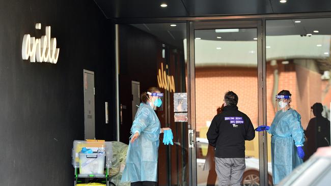 Victoria Health personnel clean the Ariele Apartments, where residents have been instructed not to leave the building. Picture: NCA NewsWire / Nicki Connolly