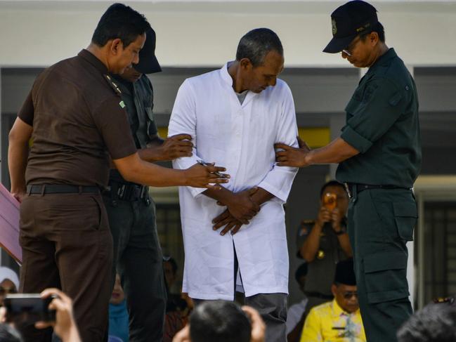 A trio of canoodling couples were publicly flogged in Indonesia's Aceh province on September 19, charged with breaking local Islamic law that outlaws public displays of affection. Picture: AFP