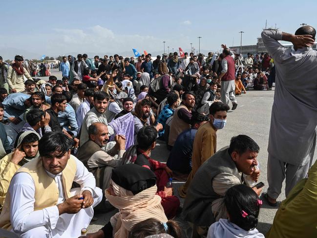 Afghan passengers sit as they wait to leave the Kabul airport in Kabul on Monday as thousands of people mobbed the city's airport trying to flee the country after the Taliban took over. Picture: Wakil Kohsar/AFP