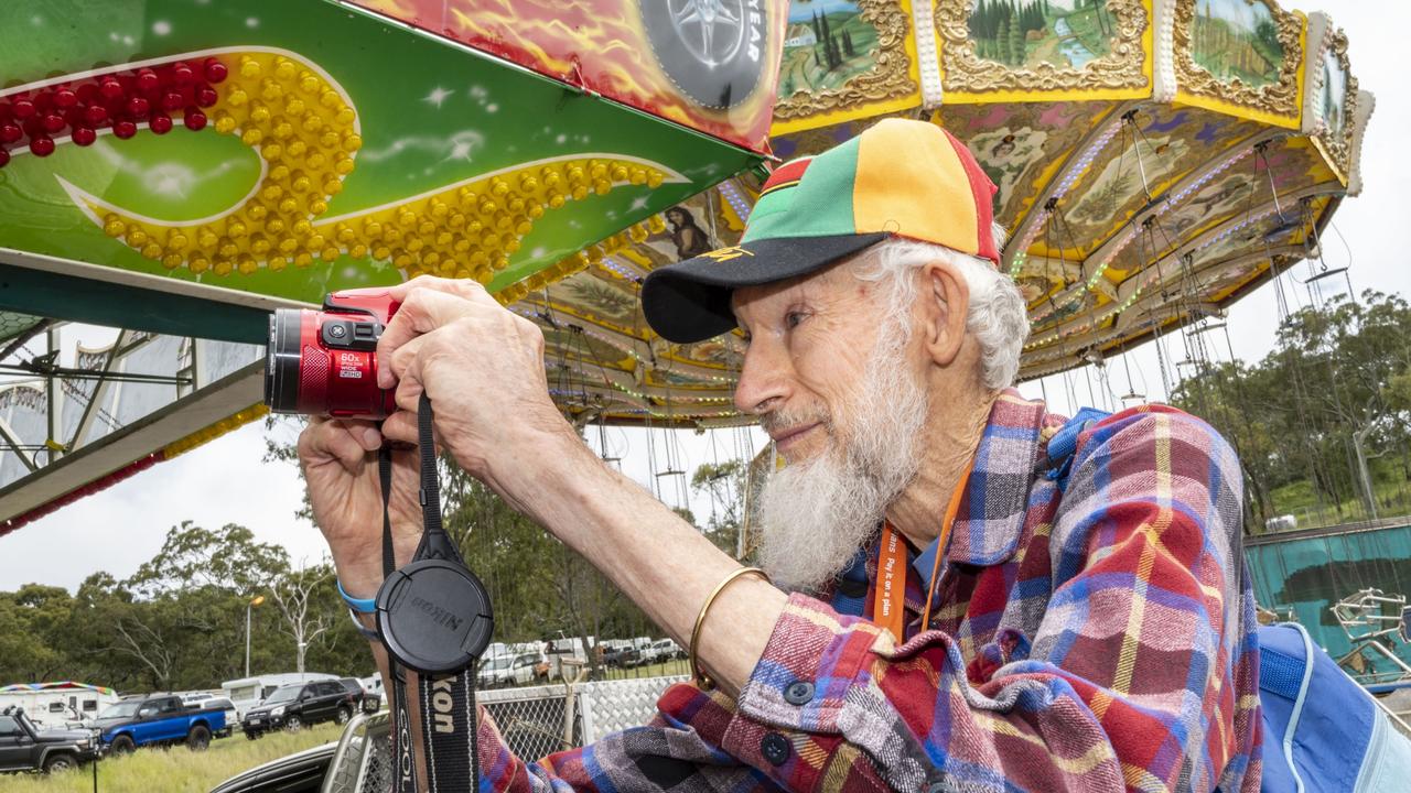 Photographer Robert Brown explores sideshow alley on day 3 of the Toowoomba Royal Show. Sunday, March 27, 2022. Picture: Nev Madsen.