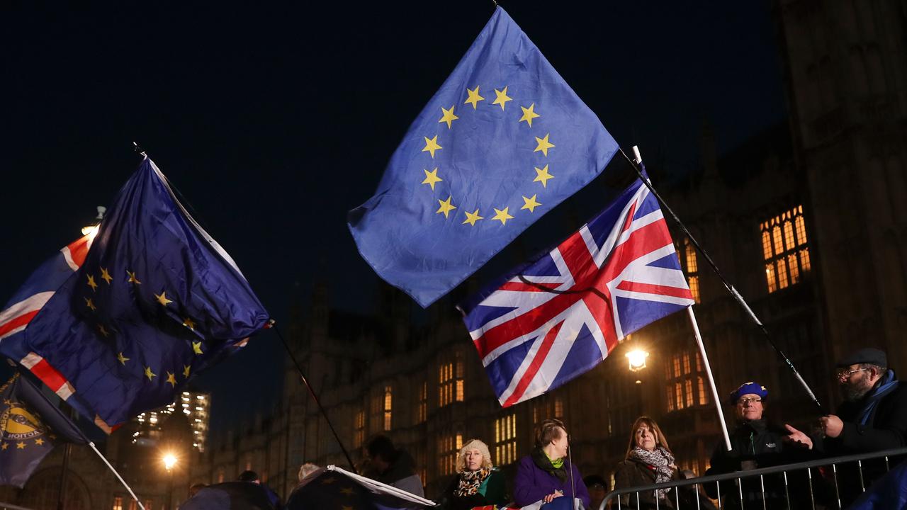 Anti-Brexit campaigners wave Union and EU flags outside the Houses of Parliament in central London. Picture: AFP 