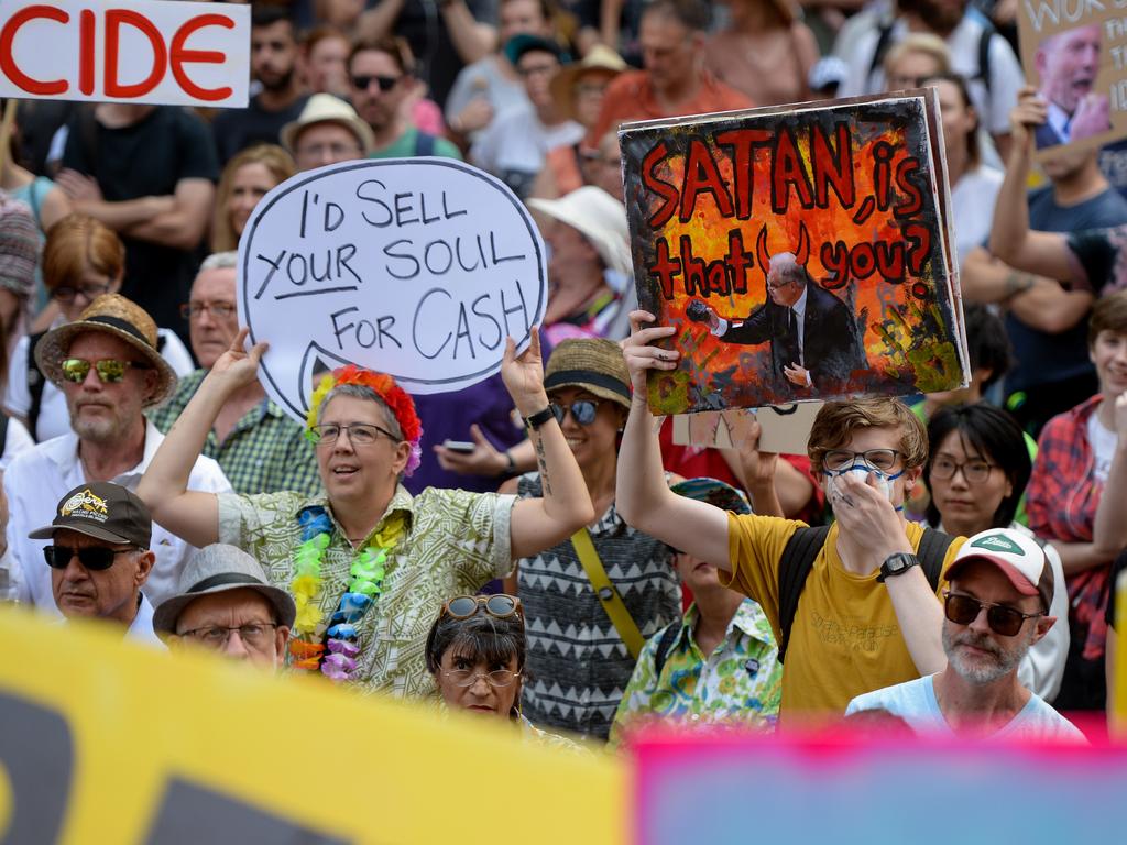 Protesters hold placards during a 'Sack ScoMo!' climate change rally in Sydney, Friday, January 10, 2020. (AAP Image/Paul Braven)