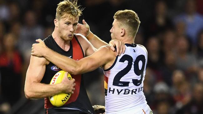 Rory Laird tackles Essendon’s James Stewart during his near-flawless match for the Crows on Friday night. Picture: Quinn Rooney/Getty Images