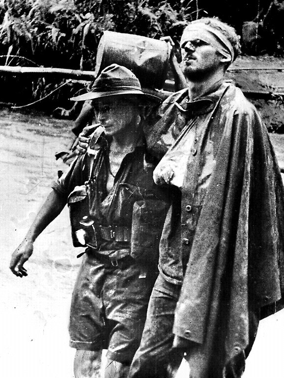 Wounded Australian soldier William 'Wally' Johnson, right, being lead by medic G R C Ayer on the Kokoda Trail, Papua New Guinea during World War II.