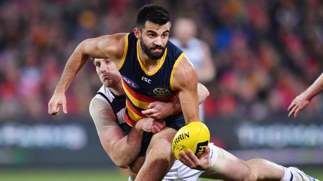 Wayne Milera of the Crows is tackled by Jed Bews of the Cats.  Picture: AAP Image/David Mariuz