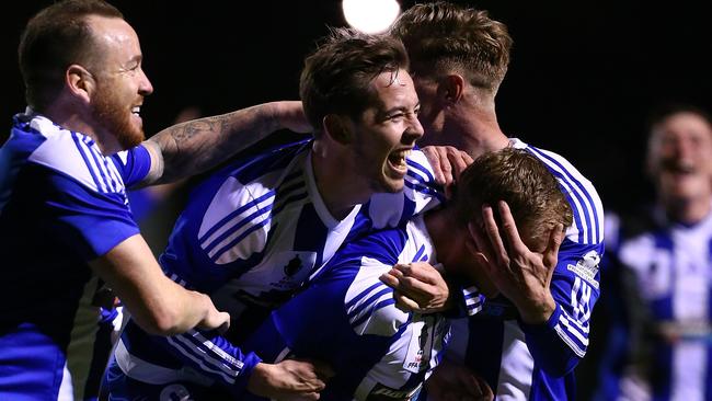 Kris Gate is swamped by his Floreat Athena teammates after scoring against Melbourne City.