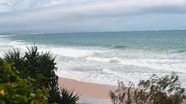 A woman is reportedly trapped on a cliff at Rainbow Beach.