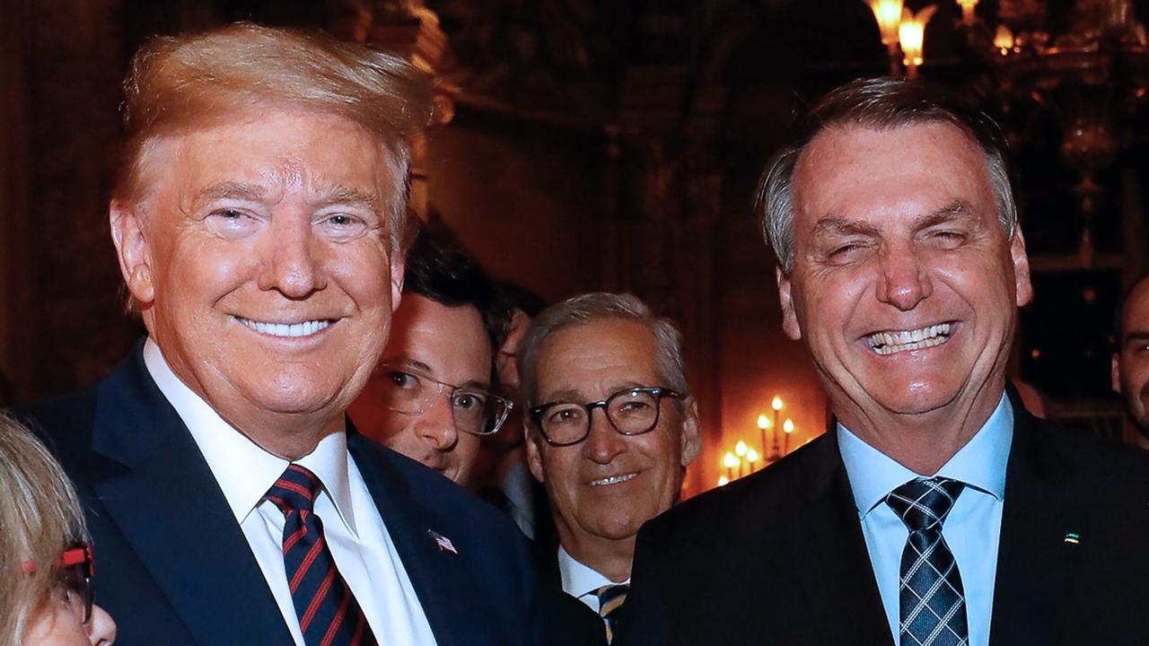 US President Donald Trump (left), Brazilian President Jair Bolsonaro (right) and his press Adviser Fabio Wajngarten (second left, behind Mr Trump) during a dinner in Mar a Lago, Florida, United States, on March 7, 2020. Picture: Alan Santos.