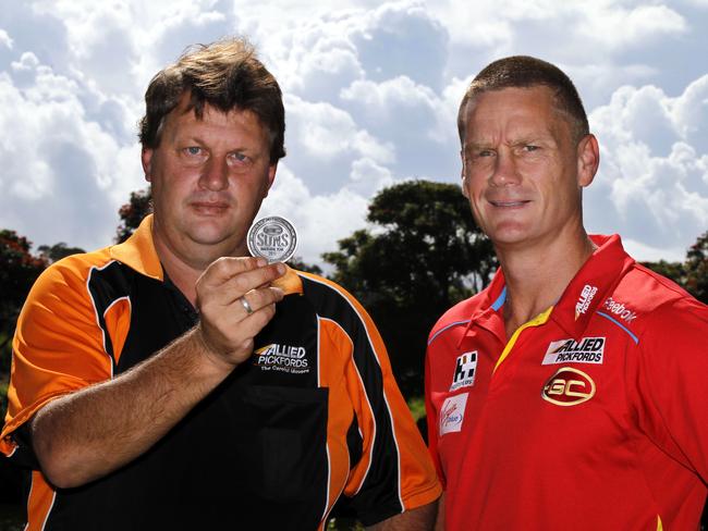 Gold Coast Suns coach Guy McKenna and Paul Fowles with a replica of the coin that he will be tossing at the first Gold Coast Suns game this Saturday in Brisbane.