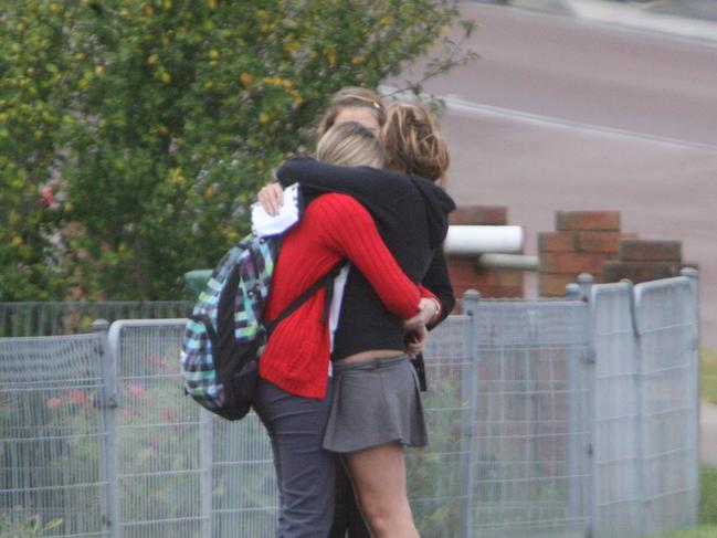 Wyong High School students console each other when they heard the news their maths teacher Amanda Carter had been murdered as they arrive for classes today 10 years ago.