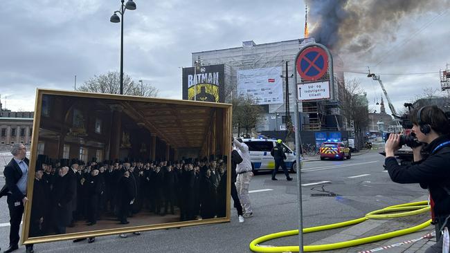 Treasures from Copenhagen's old stock exchange being saved by workers as the building burns behind them. Picture: X/Mads Bisgaard via Storyful