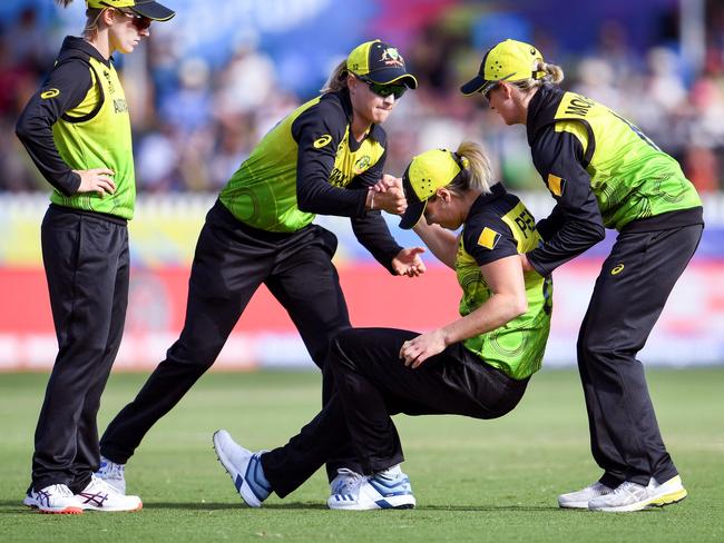 Australia's Ellyse Perry (2nd R) is helped to her feet by teammates after being injured in their Twenty20 women's World Cup cricket match against New Zealand in Melbourne on March 2, 2020. (Photo by William WEST / AFP) / -- IMAGE RESTRICTED TO EDITORIAL USE - STRICTLY NO COMMERCIAL USE --