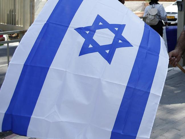 A supporter of former Israeli president Moshe Katzav imprisoned since 2011 for rape and other sexual offences, holds an Israeli flag outside the prison where he is being held in Ramla, after a parole board rejected a request for his early release on August 4, 2016. The decision came just four months after a previous attempt by the disgraced former leader to reduce a third of his seven-year sentence, which had been rejected in part because he had expressed no regret over his crimes and undergone no rehabilitative process. / AFP PHOTO / AHMAD GHARABLI