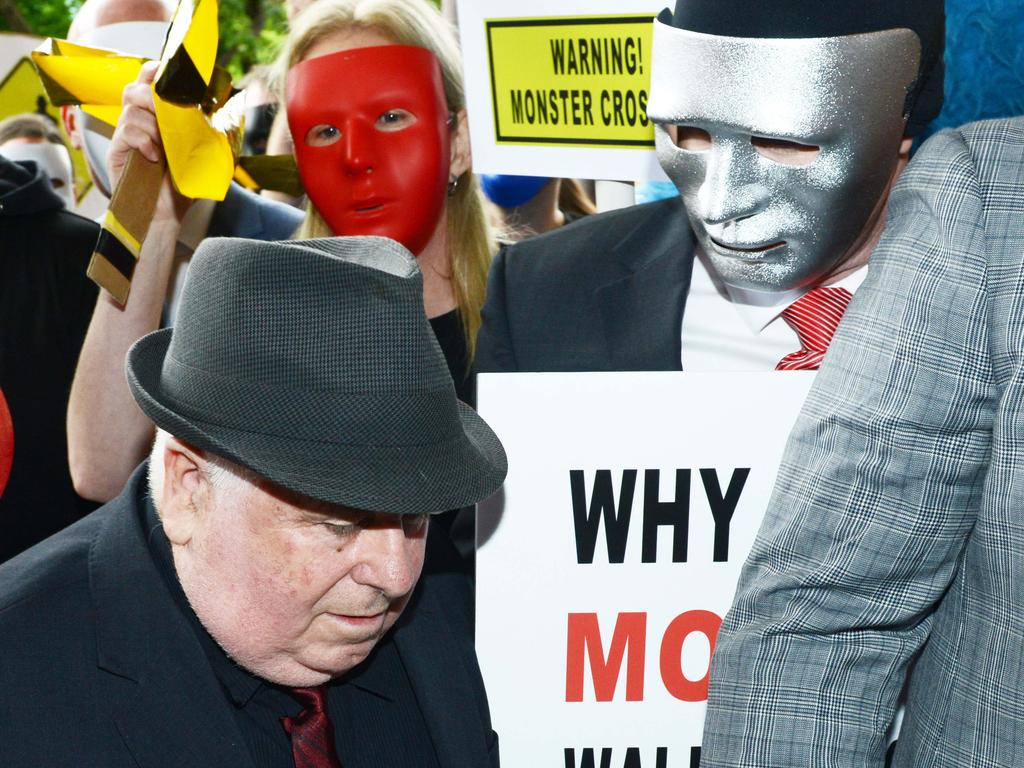 Child sex predator Vivian Deboo arrives at the District Court surrounded by protestors and supporters of his victims, Wednesday, November 28, 2018. One of his victims is in a silver mask and the other in a white mask. (AAP Image/ Brenton Edwards)