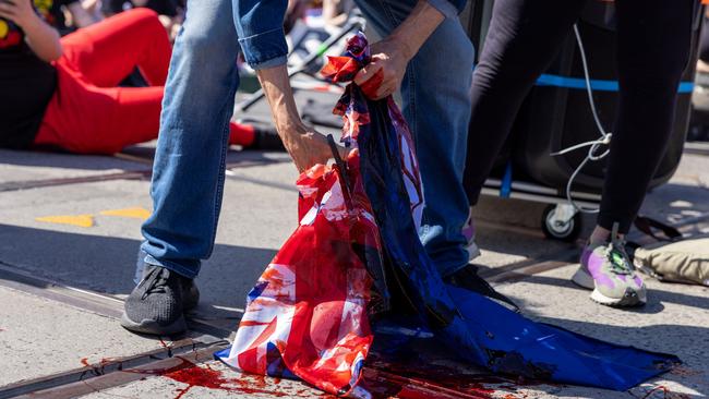 The Australian flag is cut up and has mock blood poured over it during an "Abolish the Monarchy" protest in September.