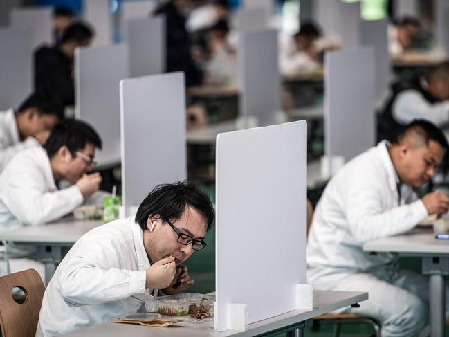 Employees at a Honda auto plant in Wuhan enjoy their lunch break, with social distancing observed. Picture: AFP