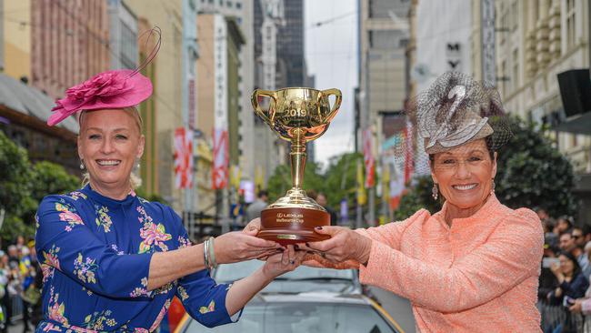 Lord Mayor Sally Capp (left) and Victoria Racing Club Chairman Amanda Elliott (right) carry the $200,000 18 carat gold Lexus Melbourne Cup through Melbourne. Picture: Jason Edwards