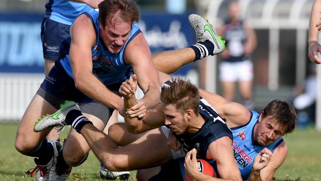 South's Tyson Brown crashes between Sturt’s Jack Osborn and Brodie Martin. Photo: Mark Brake.