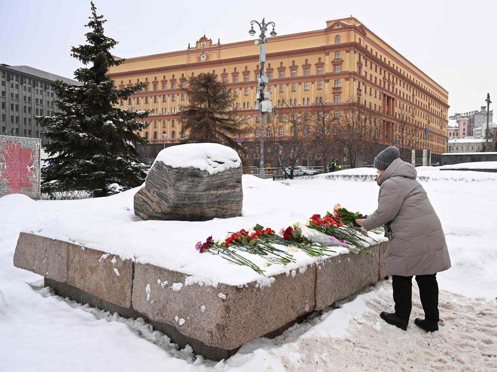 A woman lays flowers for Alexei Navalny.