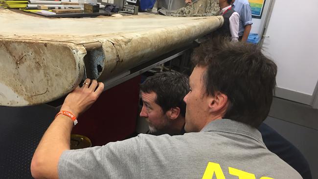 CORRECTION - This undated handout photo released by the Australia Transport Safety Bureau on July 20, 2016 shows Malaysian and Australian investigators in Canberra examining a piece of aircraft debris found on Pemba Island off the coast of Tanzania. Transport ministers from Australia, China and Malaysia will meet July 22, 2016 to discuss the future of the frustrating deep-sea search for missing flight MH370, officials said July 20. / AFP PHOTO / ATSB / Handout / RESTRICTED TO EDITORIAL USE - MANDATORY CREDIT "AFP PHOTO / AUSTRALIA TRANSPORT SAFETY BUREAU" - NO MARKETING NO ADVERTISING CAMPAIGNS - DISTRIBUTED AS A SERVICE TO CLIENTS == NO ARCHIVE / “The erroneous mention[s] appearing in the metadata of this photo by Australia Transport Safety Bureau has been modified in AFP systems in the following manner: adding CANBERRA as location. Please immediately remove the erroneous mention[s] from all your online services and delete it (them) from your servers. If you have been authorized by AFP to distribute it (them) to third parties, please ensure that the same actions are carried out by them. Failure to promptly comply with these instructions will entail liability on your part for any continued or post notification usage. Therefore we thank you very much for all your attention and prompt action. We are sorry for the inconvenience this notification may cause and remain at your disposal for any further information you may require.”