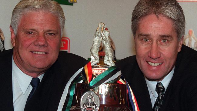 Former Adelaide Crows chief executive Bill Sanders with Port Adelaide chief executive Brian Cunningham with the first Showdown Medal and trophy in 2000. 