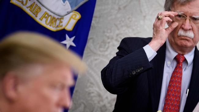 Former National Security Adviser John Bolton listens while Donald Trump speaks to the press. Picture: AFP.