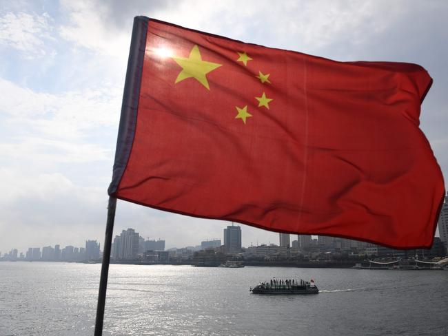 A Chinese tour boat cruises on the Yalu River behind the Chinese flag flying on the Broken Bridge, in the border city of Dandong, in China's northeast Liaoning province on September 5, 2017. The Broken Bridge once connected Dandong and the North Korean town of Sinuiju, but was bombed by the US during the Korean war and now only reaches half way across the Yalu River. / AFP PHOTO / GREG BAKER