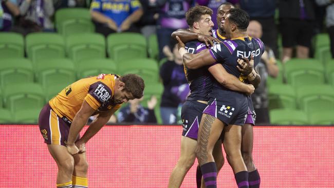 Andrew McCullough looks dejected as Curtis Scott celebrates his try dwith teammates. Picture: AAP Image/Daniel Pockett