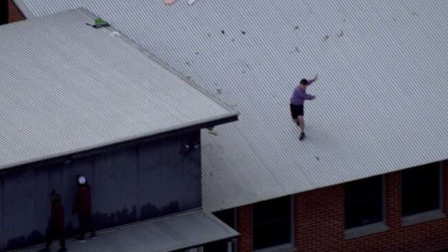 An inmate throwing an unknown object from the roof of the Banksia Hill Juvenile Detention Centre. Picture: Nine