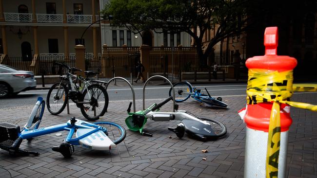 Share e-bikes from Lime and Hello Ride lay tipped over on the sidewalk at Martin Place. Picture: Max Mason-Hubers