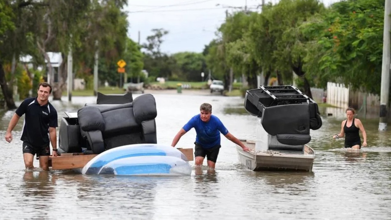 Residents use a boat and an inflatable pool to salvage furniture from flood-affected homes in Townsville during 2019 flooding. Picture: AAP Image/Dan Peled