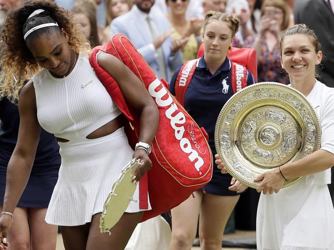 A dejected Williams leaves the court as Halep shows off her Wimbledon trophy.