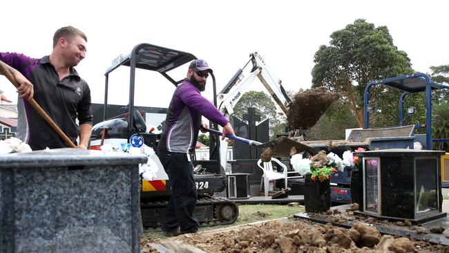 Funeral technicians backfill a grave at Rookwood Cemetery. Picture: AAP/ Justin Sanson