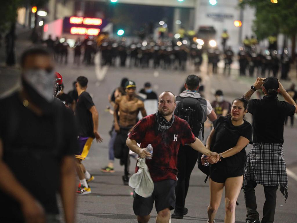 Protesters run after being tear gassed during a demonstration for the end of police brutality in uptown Charlotte, North Carolina. Picture: Logan Cyrus