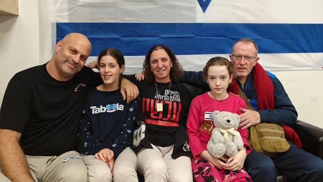 Emily Hand, second from right, reunites with her father, Tom Hand, right, while Hila Rotem, second from left, whose mother is still held hostage, reunites with family members.