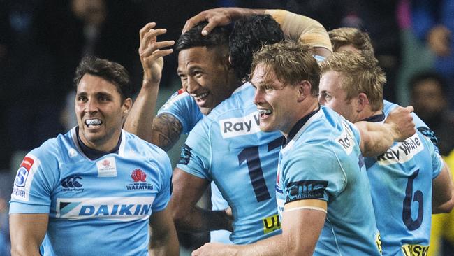 Waratahs celebrate scoring against the Highlanders.