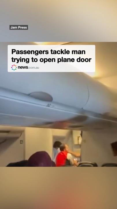 Passengers tackle man trying to open plane door